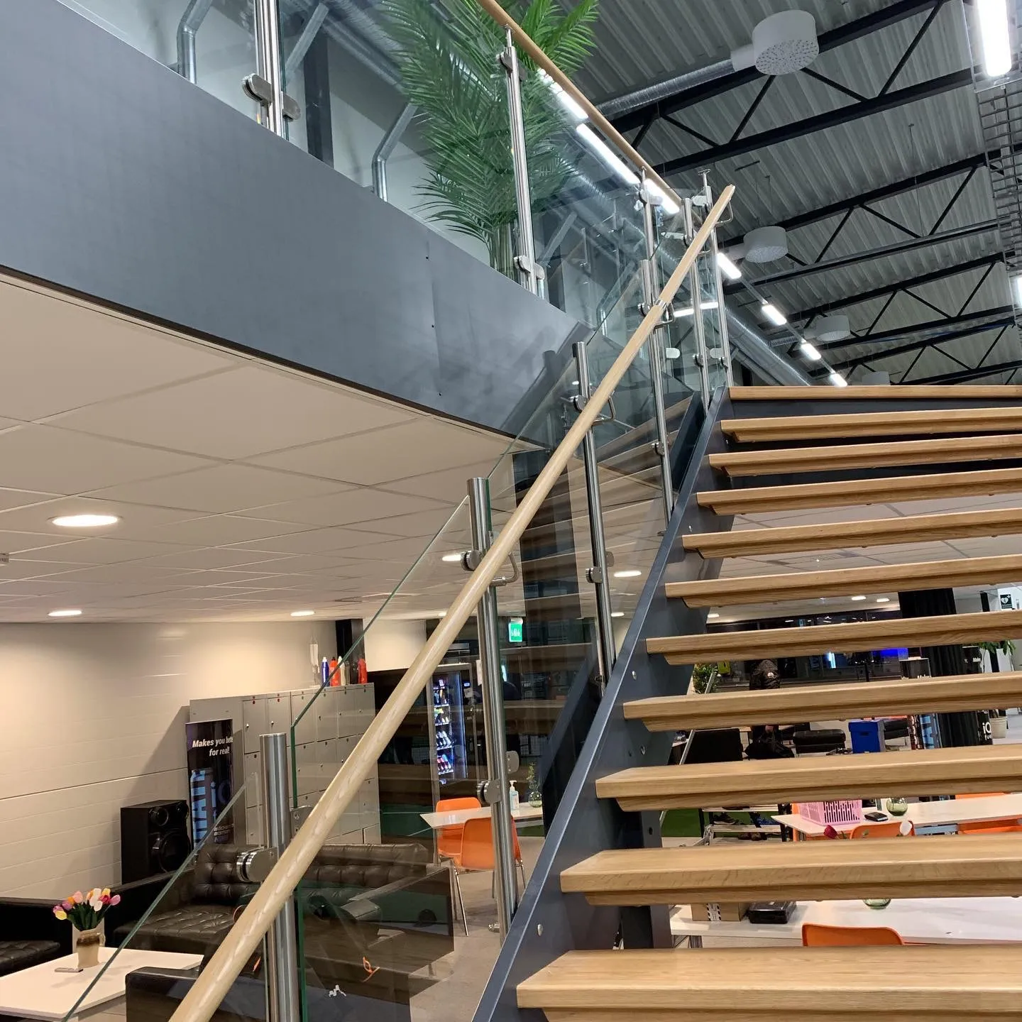 Modern inomhustrappa med trästeg och glasräcke