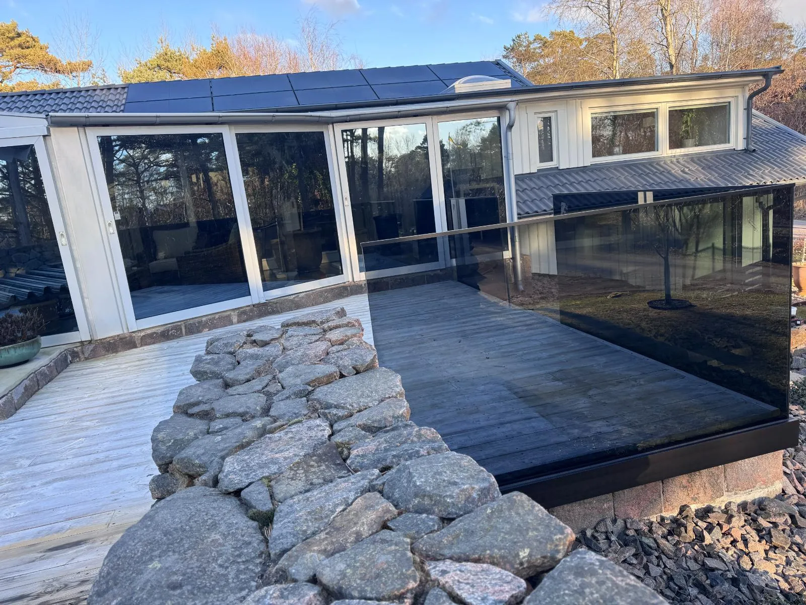 Hus med glasräcke och solpaneler